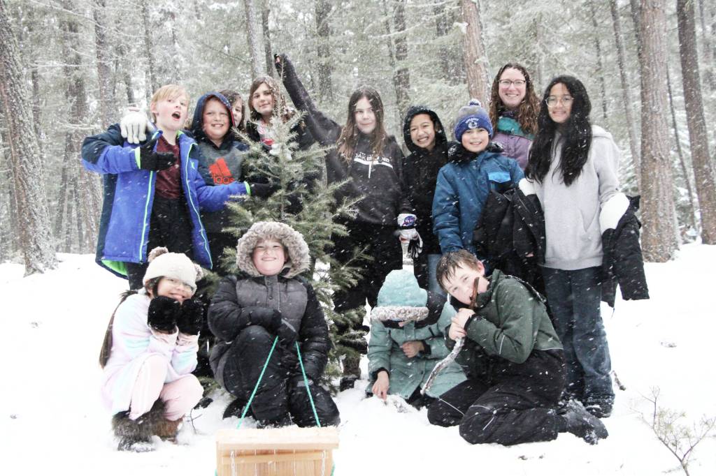 Amy Simcox’s Grade 5/6 class pose for a photo with their freshly felled Christmas tree on Friday, Dec. 5. (Patrick Davies photo - 100 Mile Free Press)